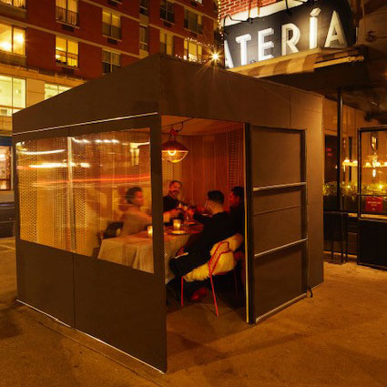 Street view of diners eating inside one of Vinatería’s outdoor dining structures